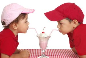 two cute kids sharing an ice cream float