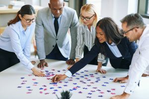 Diverse group of businesspeople working together to solve a puzzle