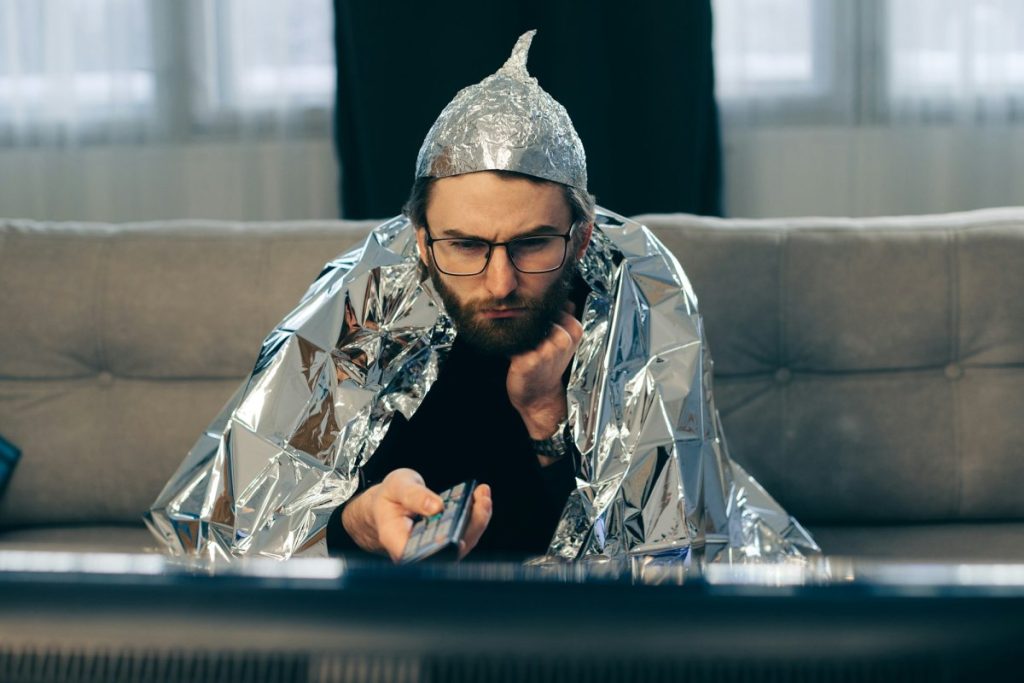 a man in a tinfoil hat watches tv
